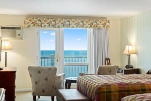 The Sparhawk Oceanfront Resort في أوجونكويت: غرفة فندقية بسرير وإطلالة على المحيط