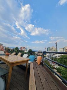 um deque de madeira com uma mesa e cadeiras numa varanda em The Rooftop Hostel em Shkodër