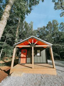 a smallshed with a red door in the middle at Cabin #10 One Bedroom W Kitchenette in Hartwell