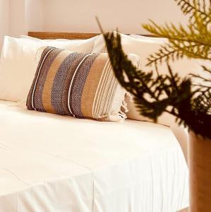 un letto con due cuscini e una pianta sopra di "Calm Joy & J" - Family a Ermoupoli