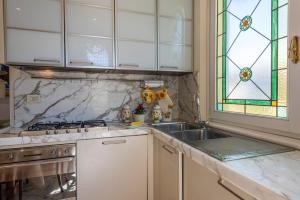 a kitchen with a sink and a stove and a window at Piave Suites by Mmega in Forte dei Marmi +30 photos