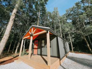 una pequeña casa con techo naranja en el bosque en Cabin #10 One Bedroom W Kitchenette, en Hartwell