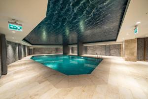 a pool in a room with a large painting on the wall at Classy, modern furnished residence-7/24 security ( benesta 64 ) in Istanbul