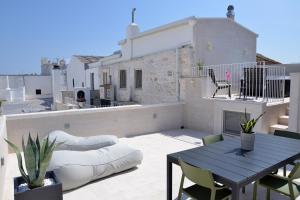 un patio con mesa y sillas en la azotea en Attico Cinquantasei, en Cisternino