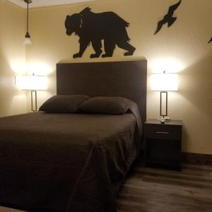 Frontier Lodge في لاندر: غرفة نوم مع تمثال الدب فوق السرير