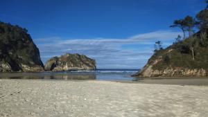 uma praia com algumas rochas no oceano em Villa Noriega (La Franca) em La Franca