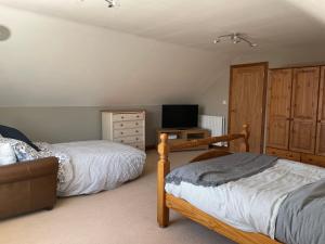 a bedroom with two beds and a television in it at Fabulous 2 Bed Apartment in Penrith