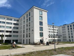 a man riding a bike in front of a building at Ferienwohnung Treibholz in Binz
