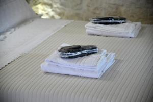 Dos toallas y un celular encima de la cama. en Attico Cinquantasei, en Cisternino