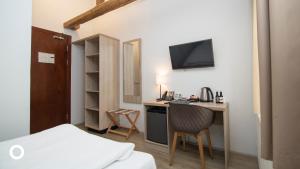 a small room with a desk and a bed and a tv at Center Hotels Plaza in Reykjav&iacute;k
