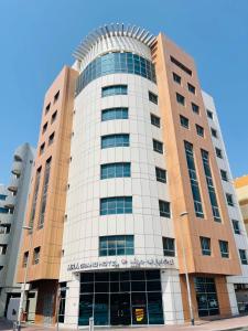 a tall white building with a sign on it at MRA Grand Hotel in Dubai