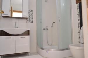 W łazience znajduje się szklana kabina prysznicowa i umywalka. w obiekcie Nalyakonak w mieście Alaçatı