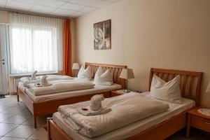 Dos camas en una habitación de hotel con animales de peluche. en Hotel Fruerlund en Flensburg