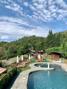 - une piscine avec des chaises et des parasols dans un complexe dans l'établissement Trout Lodge, à Collagna