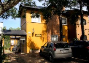 een auto geparkeerd voor een geel huis bij Puerto Escondido in Colón