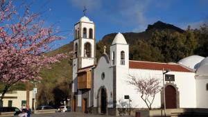 a white church with a steeple with a mountain in the background at Chinyero Path in Tamaimo
