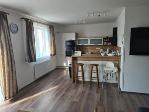 a kitchen with a counter and two bar stools at Apartmán Kuba in Frymburk