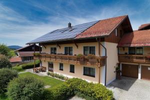 ein Haus mit Sonnenkollektoren auf dem Dach in der Unterkunft Ferienwohnungen Holzferienhäuser Leithenwald in Zwiesel