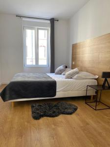 - une chambre avec un grand lit et une fenêtre dans l'établissement Les Appartements de la Gare, à Colmar