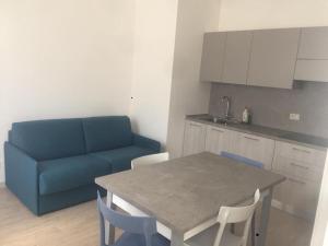 una cucina con divano blu, tavolo e sedie di Residences La Rustica & Elite a Eraclea Mare
