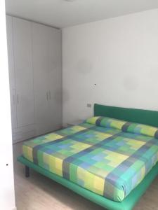 una camera da letto con un letto verde con una coperta colorata di Residences La Rustica & Elite a Eraclea Mare