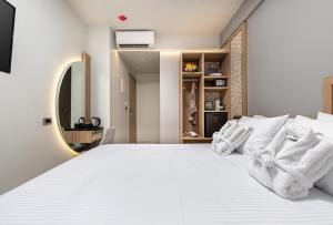 a bedroom with a white bed and a mirror at Metropolitan Pearl Boutique Hotel in Chania Town