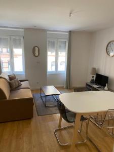 - un salon avec un canapé et une table dans l'établissement Les Appartements de la Gare, à Colmar