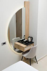 een badkamer met een spiegel en een tafel en stoelen bij Metropolitan Pearl Boutique Hotel in Chania