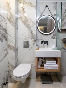 een badkamer met een wit toilet en een spiegel bij Metropolitan Pearl Boutique Hotel in Chania