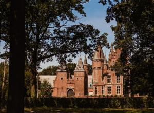 an old castle with trees in front of it at B&B Maison Lize in Lievegem