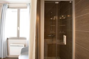 een badkamer met een douche en een glazen deur bij Chez Jostel - Chambre 2 in Genay