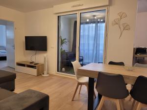 ein Wohnzimmer mit einem Esstisch und einem TV in der Unterkunft Chez Patron T3 2BR with 2 parking near Disneyland Paris & train station-Chessy in Chessy