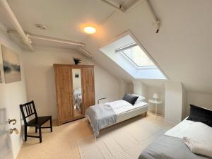 ein Dachgeschoss-Schlafzimmer mit Bett und Dachfenster in der Unterkunft Fabryka in Bergen