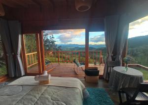 a bedroom with a bed and a balcony with a view at Glamping Paraiso en La montaña in La Calera