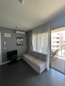 uma sala de estar com um sofá e uma grande janela em YooBulgaria-Obzor SP apartments em Obzor