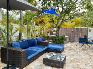 un patio con sofá azul y sombrilla en Casa con Parqueo Privado, Patio y Jacuzzi., en Santo Domingo