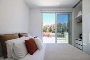 1 dormitorio con 1 cama con sábanas y almohadas blancas en Phaedrus Living - Seaside Deluxe Flat Harbour 112, en Paphos