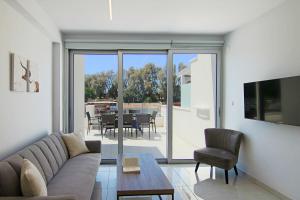 sala de estar con sofá y mesa en Phaedrus Living - Seaside Deluxe Flat Harbour 112, en Paphos