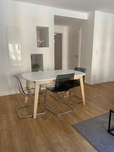 - une table et des chaises blanches dans le salon dans l'établissement Les Appartements de la Gare, à Colmar