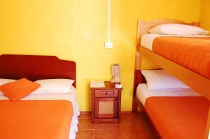 a bedroom with two bunk beds and a night stand with a lamp at Hostal Miskanty in San Pedro de Atacama