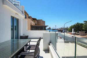 Phaedrus Living - Seaside Deluxe Flat Harbour 112 في Paphos: شرفة على طاولة وكراسي في مبنى