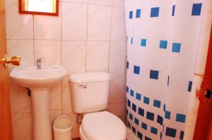 y baño con aseo y lavamanos. en Hostal Miskanty en San Pedro de Atacama