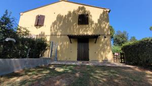 una casa gialla con una porta in un cortile di Il Gelso Nero II ad Ancona