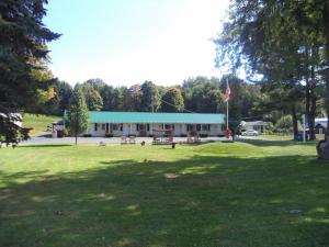 a building with a blue roof in a park at Weathervane Motel Lanesboro in Lanesborough