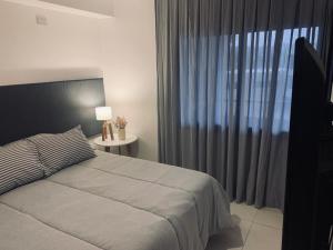 a bedroom with a bed and a large window at DPTO EN VILLA ALLENDE A ESTRENAR !! in Villa Allende
