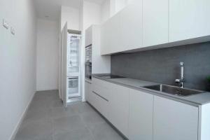 a white kitchen with a sink and a refrigerator at Mike House Alójate en el corazón de Zaragoza in Zaragoza