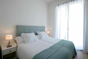 una camera da letto con letto con testiera blu e finestra di Mike House Alójate en el corazón de Zaragoza a Saragozza