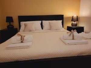 a bedroom with a large white bed with towels on it at La Perla Di Noto in Noto