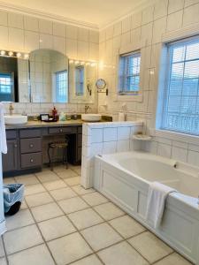 a large white bathroom with a tub and two sinks at Barren Breeze Bed and Breakfast in Lucas
