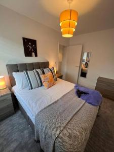 a bedroom with a bed with a cat sitting on it at Stay at The Penn! 5 Bedroomed home in Treharris in Treharris